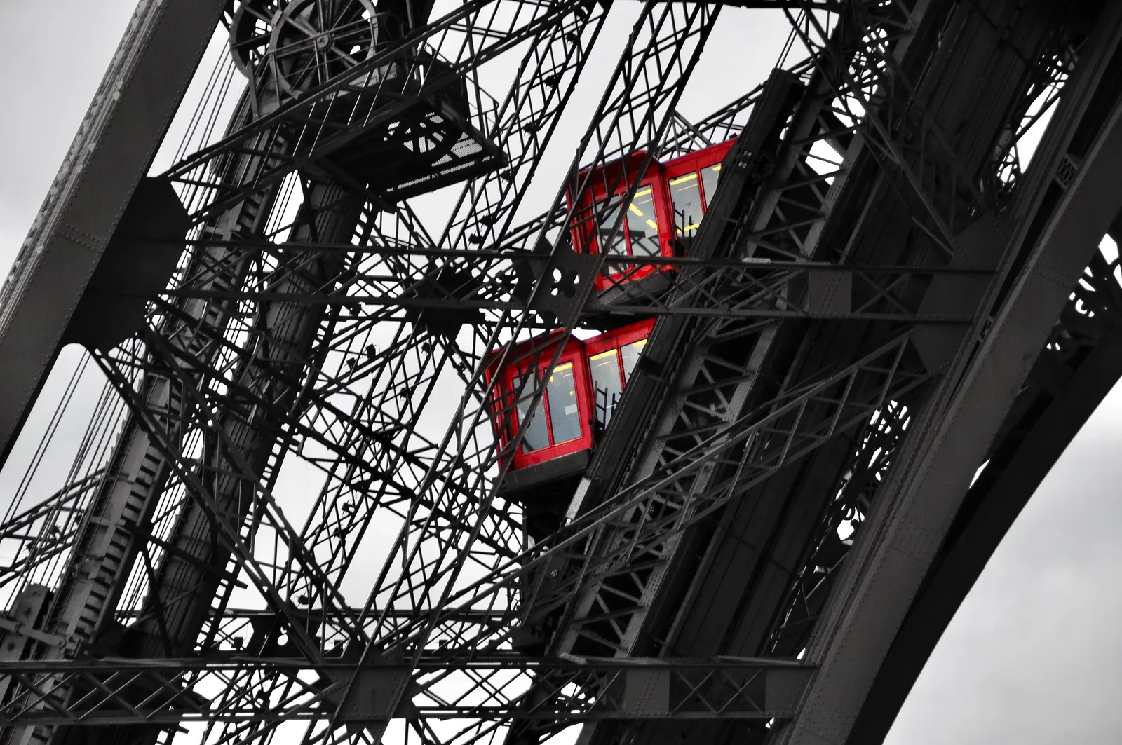 Eiffel Tower ironwork with red lift cars